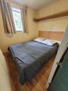 a bed in a small room with a bed sidx sidx sidx at Camping 3 étoiles - Piscine - ccbfi0e in Mauroux