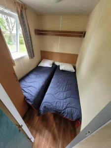 two beds in a small room with a window at Camping 3 étoiles - Piscine - ccbfi0e in Mauroux