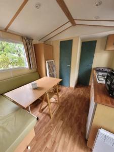 a small kitchen with a table and a stove at Camping 3 étoiles - Piscine - ccbfi0e in Mauroux