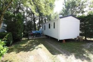 a white tiny house in the middle of a yard at Camping 3 étoiles - Piscine - ccbfi0e in Mauroux