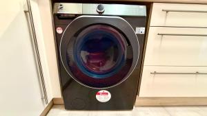 eine Waschmaschine mit offener Tür in einer Küche in der Unterkunft Villa Cologne - Apartments & Monteursquartiere in Meckenheim bei Köln in Meckenheim