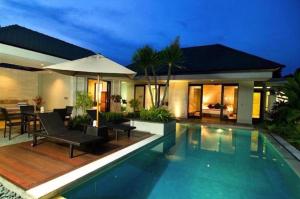 a villa with a swimming pool at night at Villa Kejora 10 in Sanur