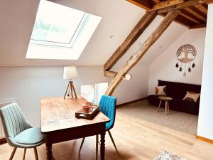 a living room with a skylight and a table and chairs at Superbe maison en pierre in Sault-Brénaz