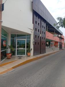 an empty street in front of a building at Hotel del angelinn in Martínez de La Torre