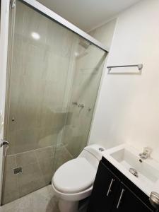 a bathroom with a shower and a toilet and a sink at Aluna Hotel, Laureles Medellín in Medellín