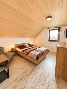 a bedroom with a large bed in a wooden ceiling at Vila Svistovka in Stará Lesná