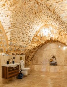 a stone bathroom with a sink and a toilet at Rocinante House in Mardin