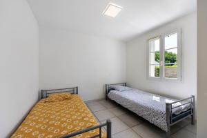 a bedroom with two beds and a window at La Barbâtrine in Barbâtre