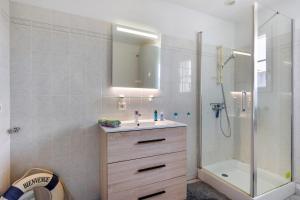 a bathroom with a sink and a shower with a mirror at La Barbâtrine in Barbâtre +19 photos