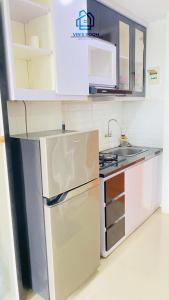 a kitchen with a refrigerator and a sink at Vinsroom Dua at Green Park in Seturan