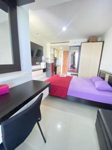 a bedroom with a bed and a desk and a kitchen at Vinsroom Dua at Green Park in Seturan