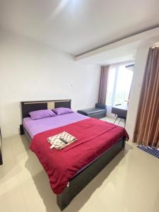 a bedroom with a bed with a red blanket at Vinsroom Dua at Green Park in Seturan