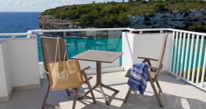 a table and chairs on a balcony with the ocean at Blau Punta Reina in Cala Mendia