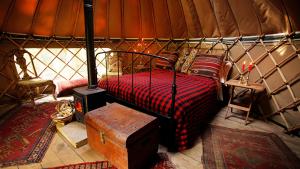 a bedroom with a bed and a table in a yurt at Adhurst Yurts in Sheet +17 photos