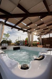 a jacuzzi tub in a backyard with an umbrella at En Sophia Guesthouse in Maronia