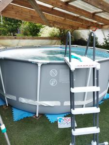 a bathtub with a ladder next to a swimming pool at Tiny House cosy, jardin romantique forestier, route du vin, sentiers in Lalaye