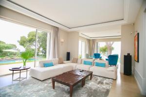 a living room with a white couch and blue chairs at Villa Cœur de Mer in Nice
