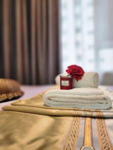 a pile of towels and a red rose on a table at Ulaanbaatar Sky Residence in Ulaanbaatar