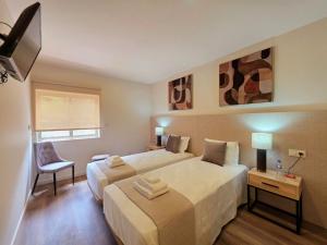 a hotel room with two beds and a chair at AL Ponto Norte in Melgaço