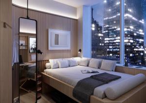 ein Schlafzimmer mit einem großen Bett und einem großen Fenster in der Unterkunft Little Something Hotel NYC in New York