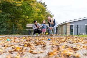 a family playing with fallen leaves in a park at Resort Mooi Bemelen in Bemelen +197 photos