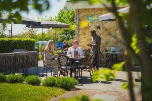 two people sitting at a table in a garden at Resort Mooi Bemelen in Bemelen