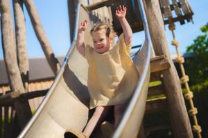 a young girl on a slide at a playground at Resort Mooi Bemelen in Bemelen