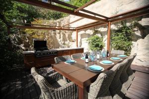 a wooden table and chairs on a patio with a grill at Villa Cœur de Mer in Nice