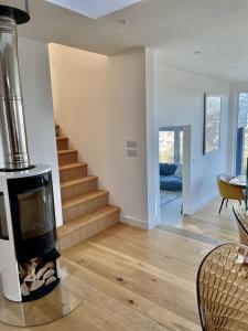 a living room with a fireplace and stairs at Mincarlo House in St Austell +18 photos