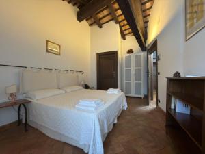 a bedroom with a white bed in a room at Volpe Pasini - Wine and Rooms in Togliano