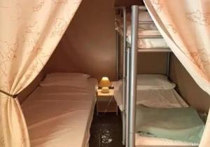 a couple of bunk beds in a small room at Camping 3 étoiles - Piscine - ccbfhii in Bouzic +50 photos