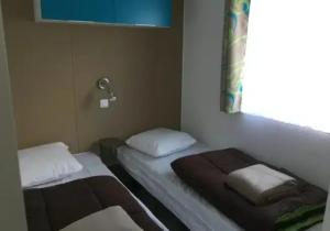 two beds in a room with a window at Camping 3 étoiles - Piscine - ccbfhii in Bouzic
