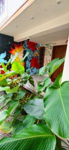 a room with green plants in front of a mural at The Mystery palace in Varkala +4 photos