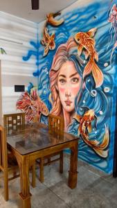 a mural of a woman with fish on a wall at The Mystery palace in Varkala