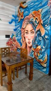 a mural of a woman with fish on a wall at The Mystery palace in Varkala