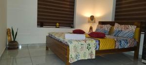 a bedroom with a bed with red pillows at The Mystery palace in Varkala