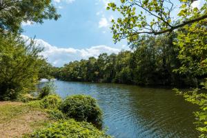 a river with trees on the side of it at Camping Onlycamp le Clos Imbert in Thouars