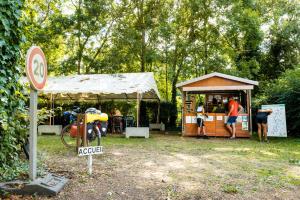 a small building with people standing outside of it at Camping Onlycamp le Clos Imbert in Thouars