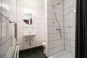 a bathroom with a shower and a toilet and a sink at Hotel en Grand Café De Pauw in Roermond