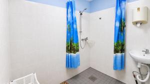 a bathroom with blue shower curtains and a sink at Paide Event Center Hostel in Prääma +73 photos