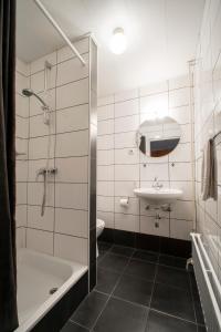 La salle de bains est pourvue d'une baignoire, d'un lavabo et d'une douche. dans l'établissement Hotel en Grand Café De Pauw, à Ruremonde