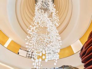 Ein großer weißer Kronleuchter hängt von der Decke. in der Unterkunft Fairmont Doha in Doha