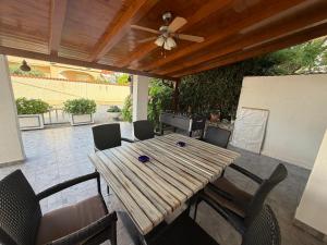 a wooden table and chairs on a patio at More Space, More Memories -Lana Rab Apartment in Rab