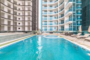 a swimming pool with two tall buildings in the background at Sea View Apartment with Balcony in Ajman 