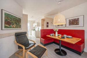 a living room with a red couch and a table and a chair at Ferienanlage Seeblick Kunstquartier in Koserow