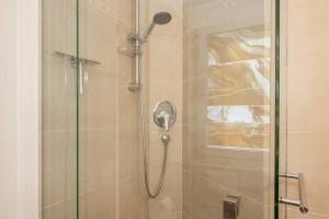 a shower with a shower head in a bathroom at Ferienanlage Seeblick Kunstquartier in Koserow +24 photos