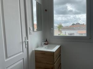 a bathroom with a sink and a window at The Corner Pavillon in Noirmoutier-en-l'lle
