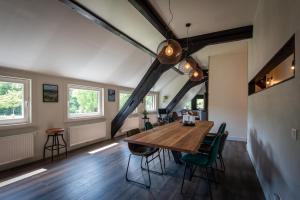 a dining room with a wooden table and green chairs at Haus zur Mühle in Winterberg