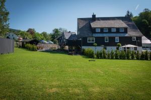 a house in a yard with a green lawn at Haus zur Mühle in Winterberg
