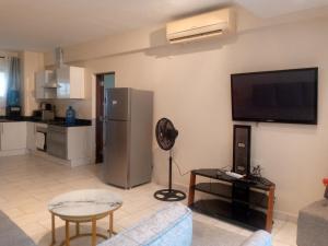 a living room with a couch and a tv on a wall at Heaven place -1 bedroom beachfront unit in Ukunda